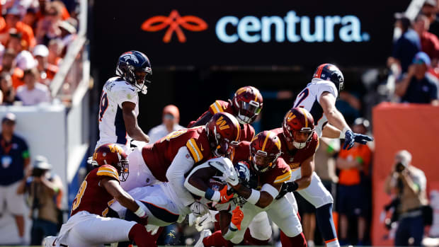 Sep 17, 2023; Denver, Colorado, USA; Denver Broncos running back Javonte Williams (33) is tackled by Washington Commanders cornerback Kendall Fuller (29) and defensive tackle Daron Payne (94) and safety Darrick Forrest (22) and linebacker Cody Barton (57) in the second quarter at Empower Field at Mile High. Mandatory Credit: Isaiah J. Downing-USA TODAY Sport